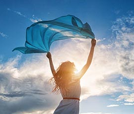 Frau im Wind mit Sonnenlicht - Hyperlink zu gratis Pranic Healing Kurzbehandlung