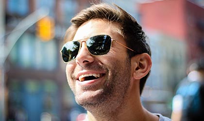 Mann lachend mit Sonnenbrille