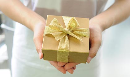 Frau hält goldenes Geschenk in der Hand