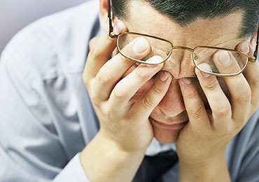 Mann hält sich den Kopf - TRE Anwendungsbereich Stress