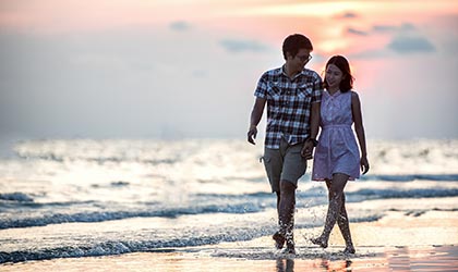 Paar spatziert am Strand in der Abenddämmerung