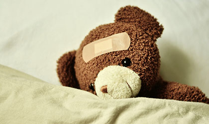 Brauner Teddy mit Pflaster am Kopf