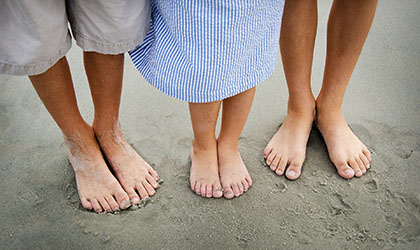 Drei Fusspaare im Sand